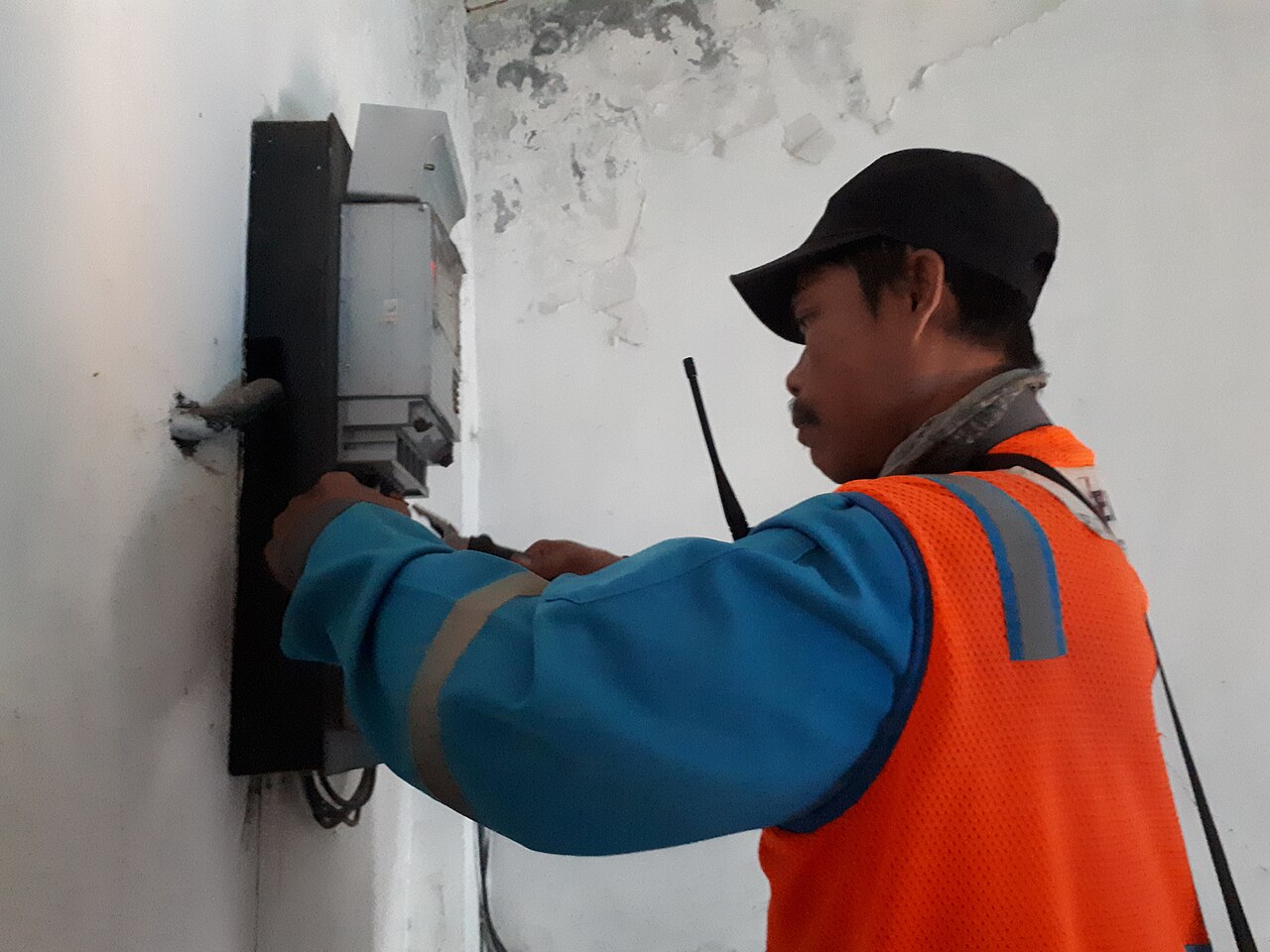 Técnicos trabajan sobre un medidor de electricidad